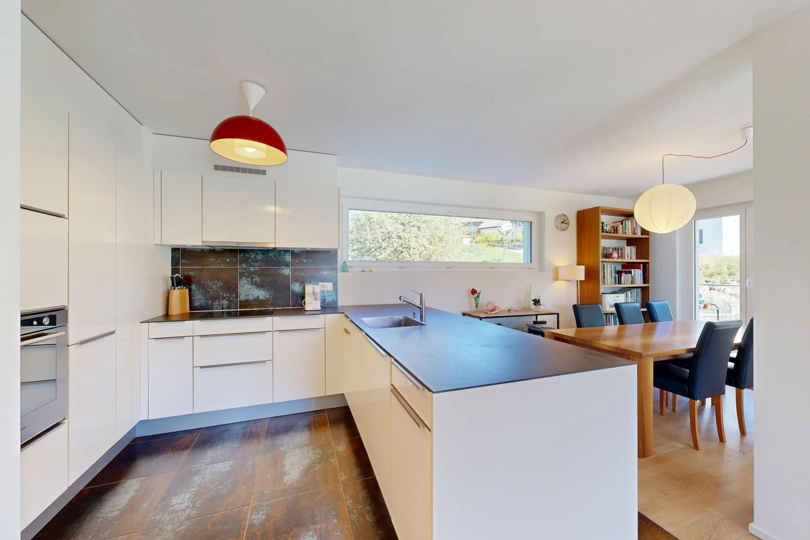 cuisine avec armoires à panneau plat, flat panel cabinets, péninsule de cuisine, kitchen peninsula, et dark floor
