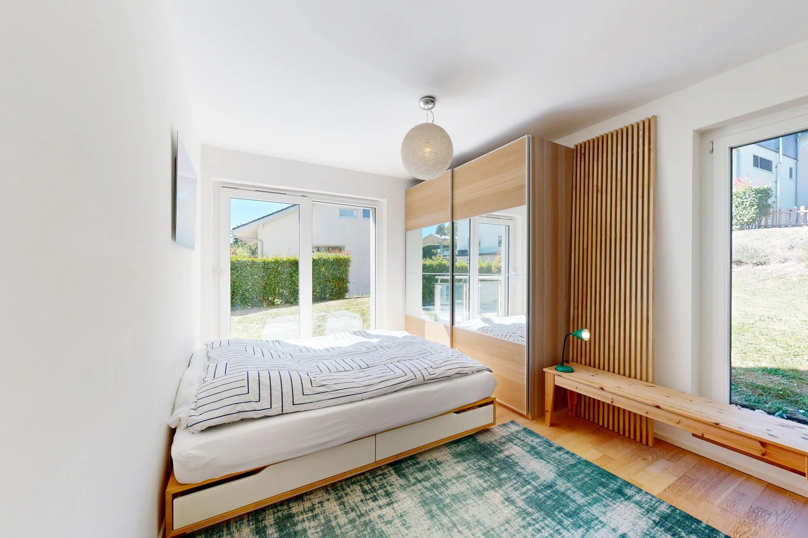 chambre avec accès à l'extérieur, drywall, cloison sèche, wood finish floor, et sol en finition bois