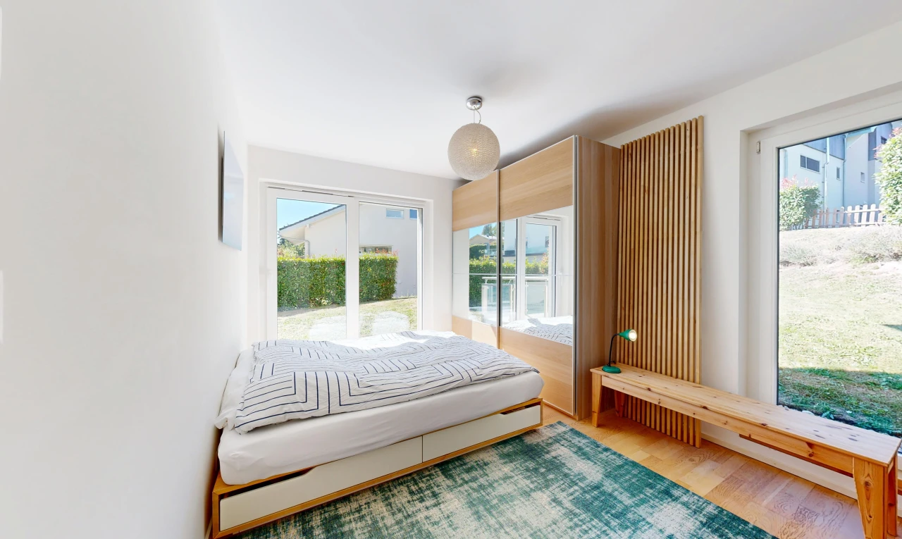 chambre avec accès à l'extérieur, drywall, cloison sèche, wood finish floor, et sol en finition bois