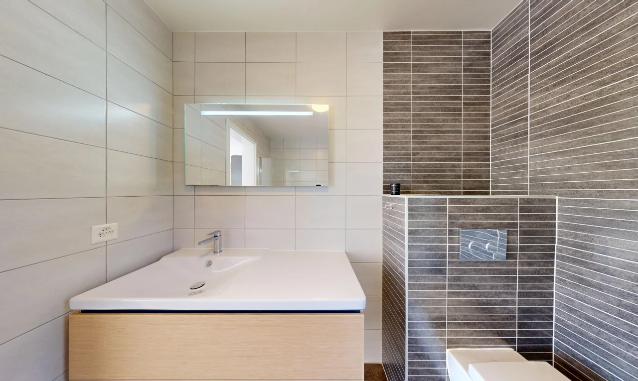 salle de bains avec miroir, tile wall, mur en carrelage, lavabo (ou coiffeuse selon le contexte), et évier
