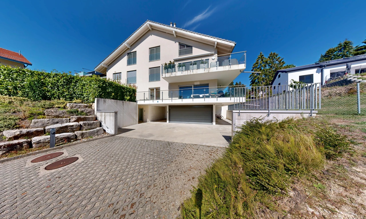 façade avec balcon, allée, garage intégré, bardage en stuc, et garage au sous-sol