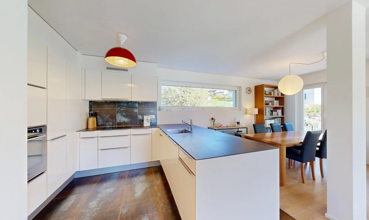 cuisine avec armoires à panneau plat, flat panel cabinets, péninsule de cuisine, kitchen peninsula, et dark floor