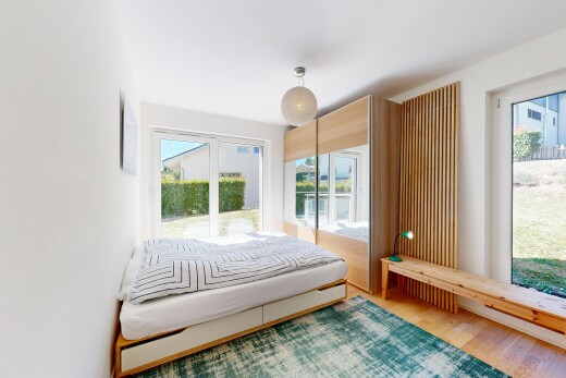 chambre avec accès à l'extérieur, drywall, cloison sèche, wood finish floor, et sol en finition bois