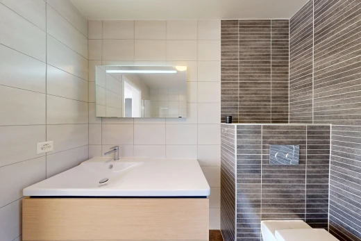 salle de bains avec miroir, tile wall, mur en carrelage, lavabo (ou coiffeuse selon le contexte), et évier