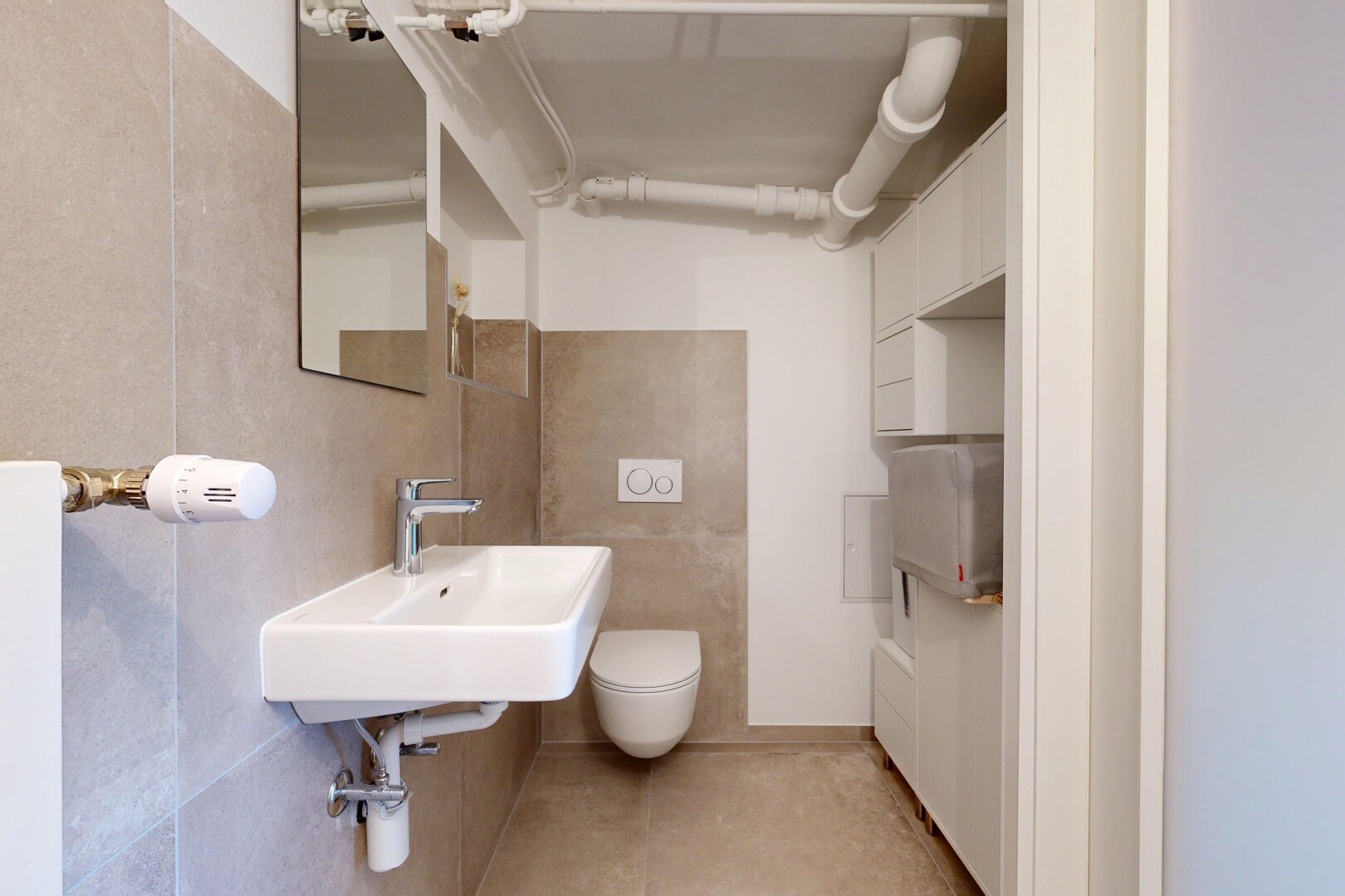 salle de bains avec miroir, évier, light floor, toilette, et inside community