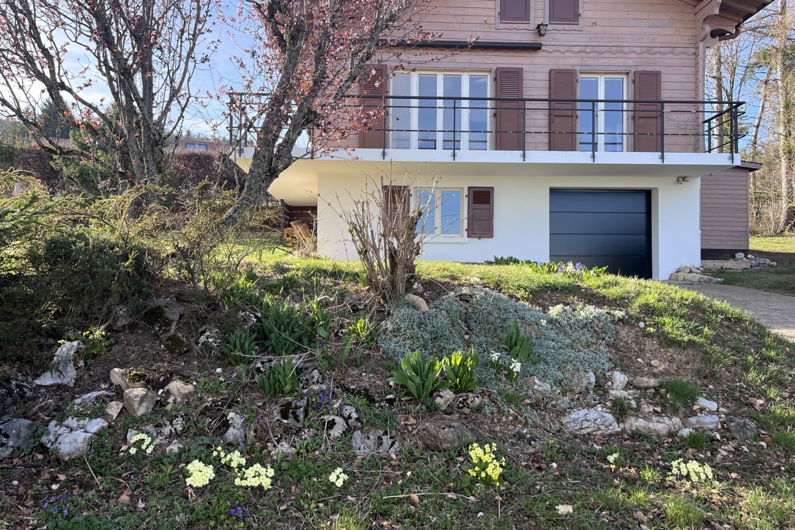façade avec bardage horizontal, balcon, property visible, garage intégré, et day time