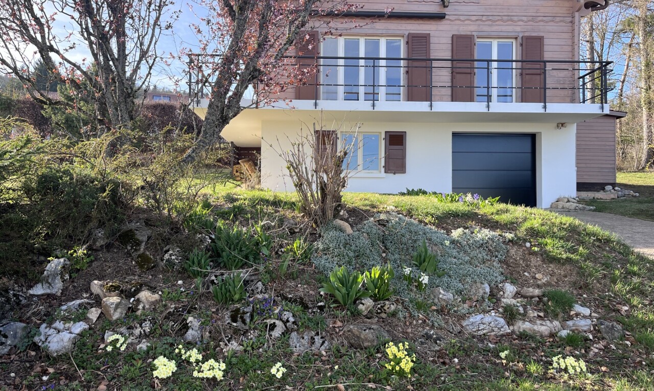 façade avec bardage horizontal, balcon, property visible, garage intégré, et day time