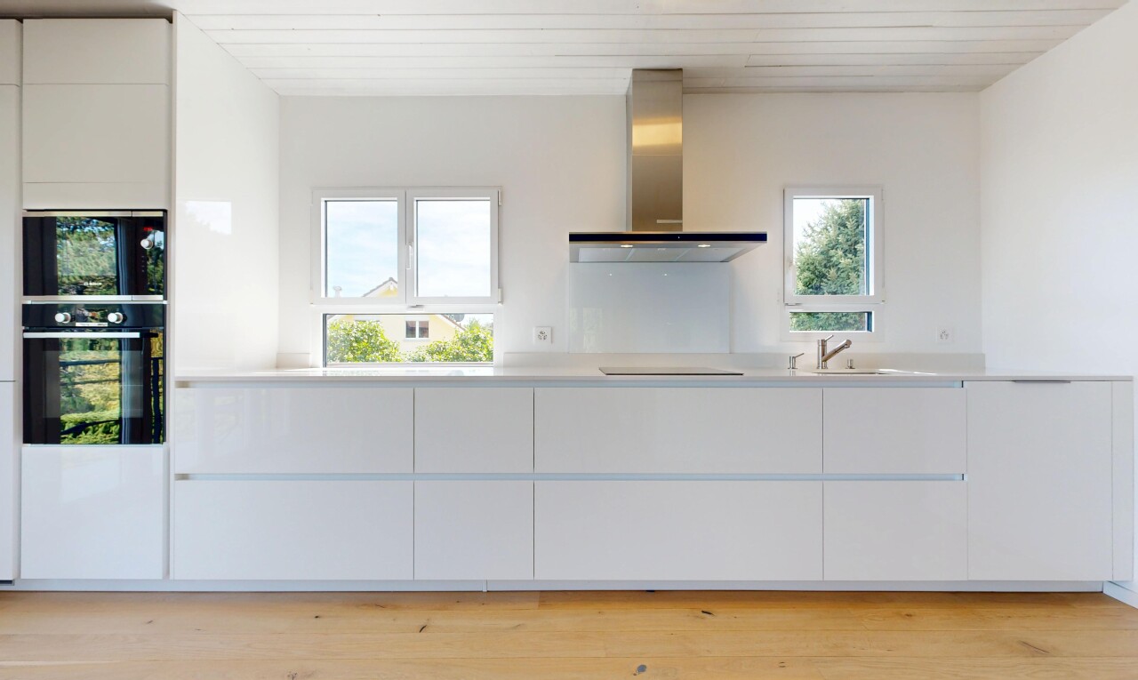 cuisine avec hotte, flat panel cabinets, armoires à panneau plat, light countertops, et plans de travail
