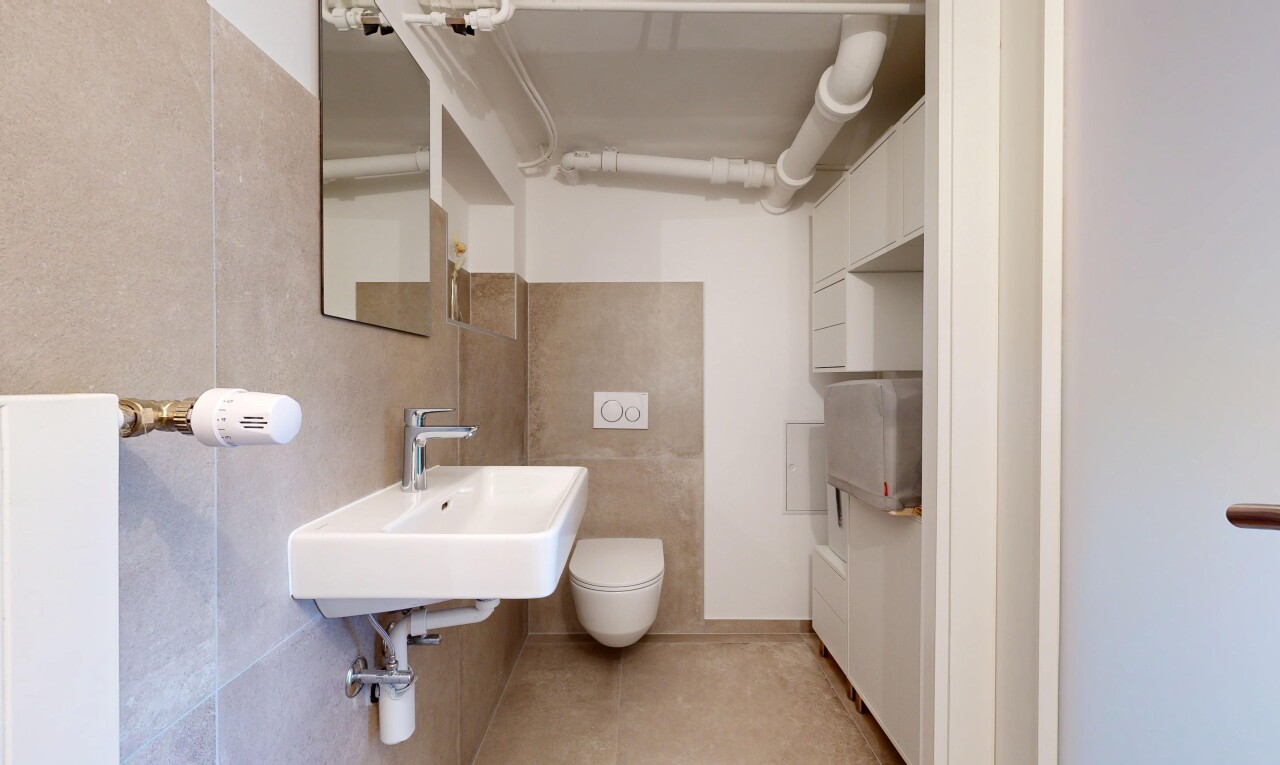 salle de bains avec miroir, évier, light floor, toilette, et inside community