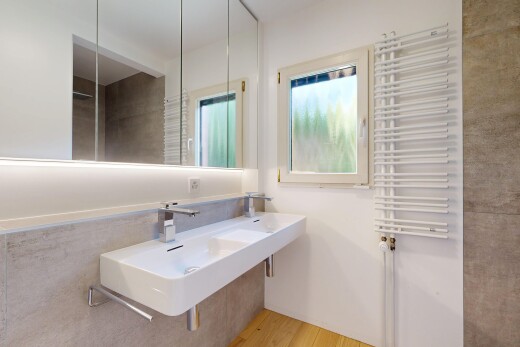full bath with radiator heating unit and light wood-style floors
