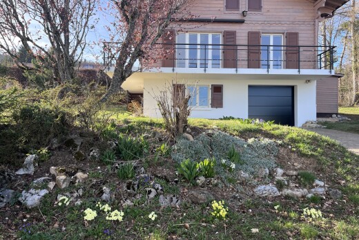 view of home with a balcony, an attached garage, and stucco siding