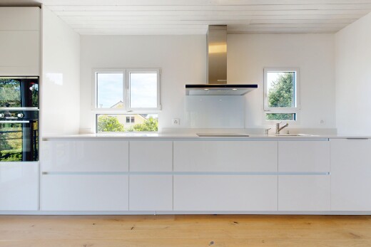 kitchen featuring modern cabinets, light countertops, black appliances, white cabinets, and light wood-style flooring
