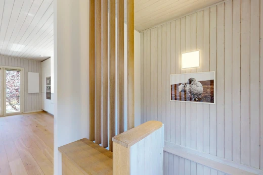 couloir avec mur en bois, wood wall, inside property, sol en finition bois, et wood finish floor