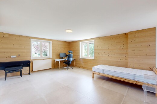 room / bedroom featuring an office area and wooden walls