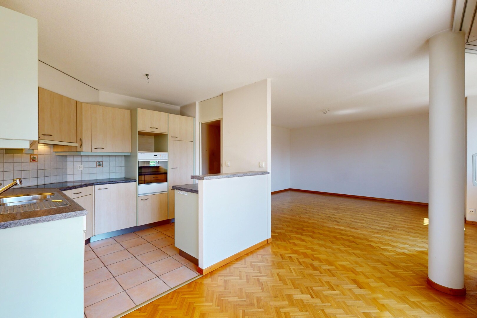 cuisine avec plans de travail, dark countertops, dosseret, backsplash, et armoires marron clair