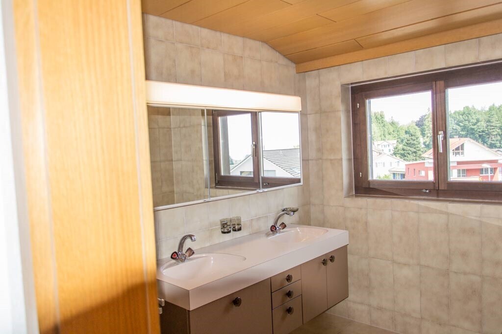 salle de bains avec double vasque, miroir, plafond en bois, wood ceiling, et lumière naturelle