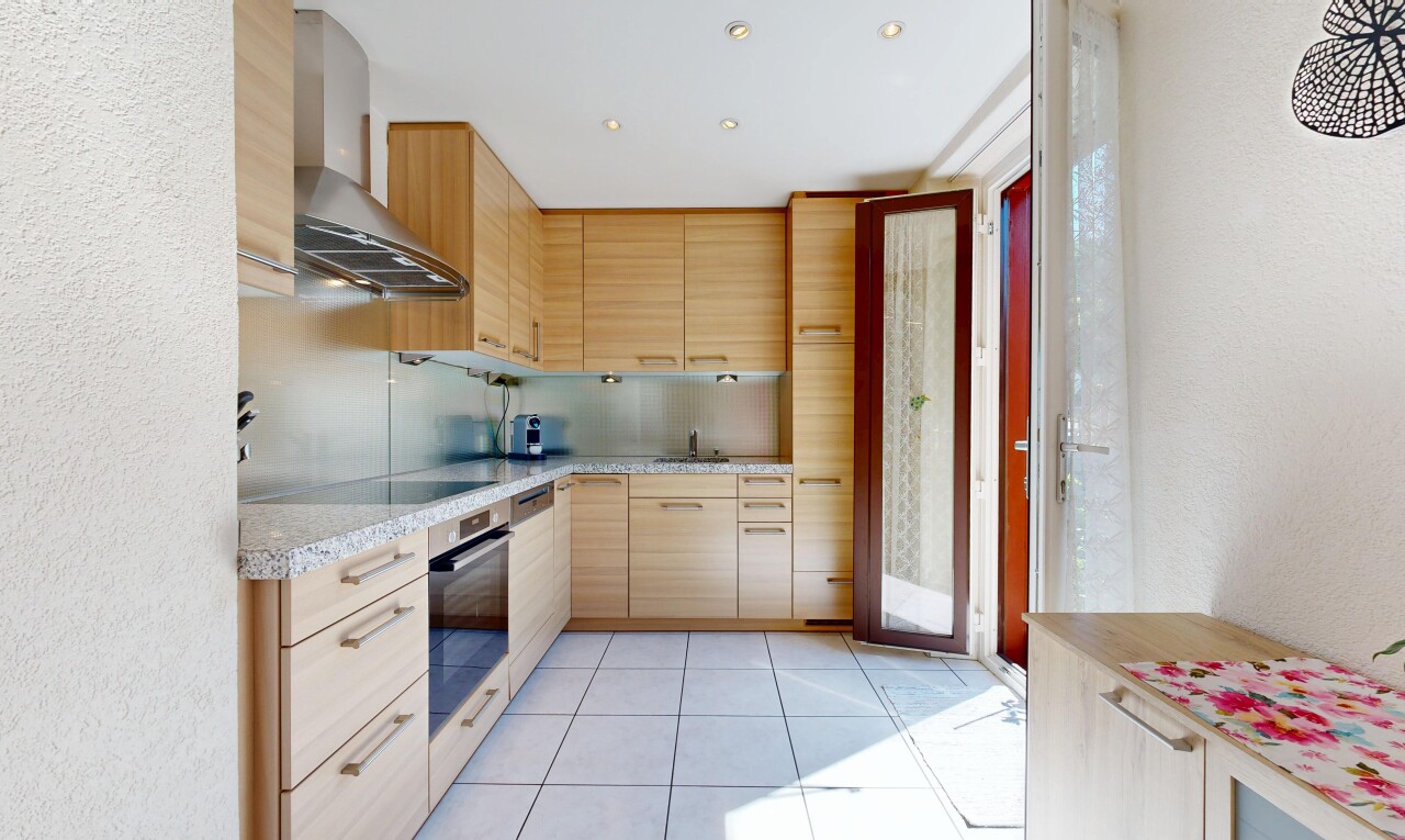 cuisine avec armoires marron clair, light brown cabinets, hotte, four, et light countertops