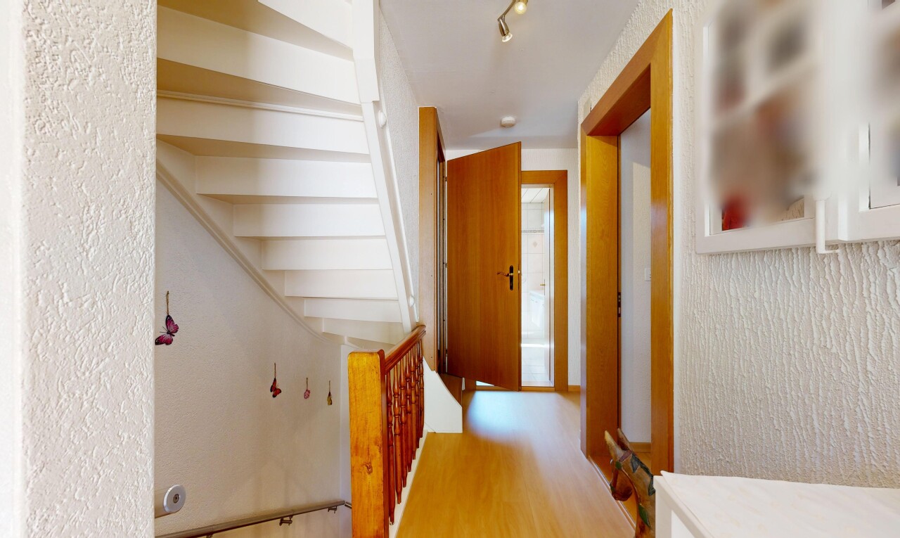 couloir avec inside property, sol en finition bois, wood finish floor, mur texturé, et textured wall