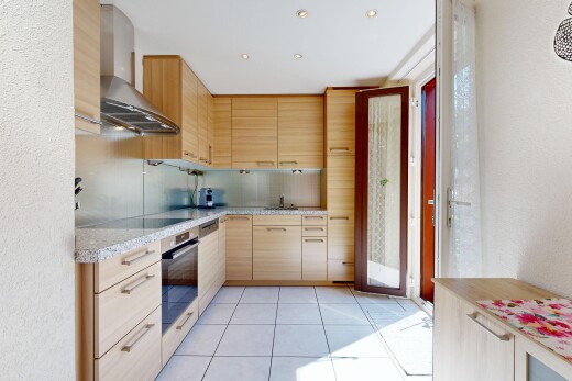 cuisine avec armoires marron clair, light brown cabinets, hotte, four, et light countertops