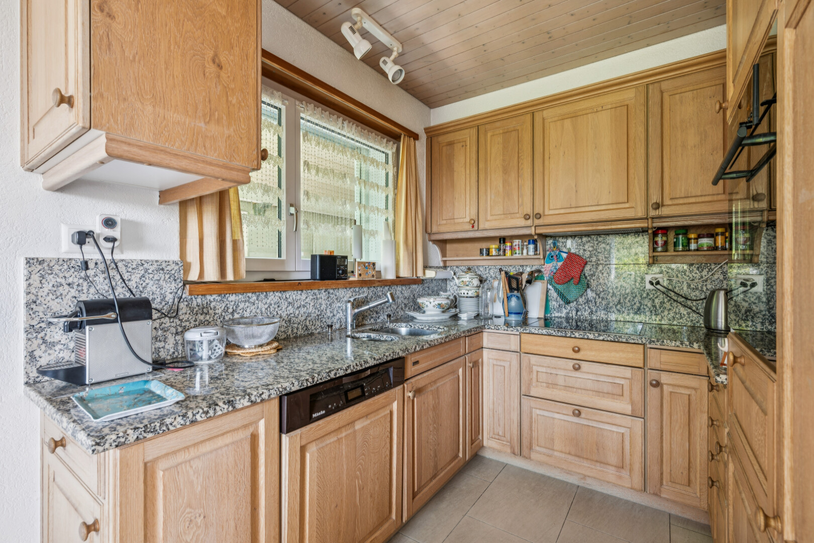 küche mit deckenbeleuchtung, stone countertops, stein arbeitsplatten, geschirrspülmaschine, und light floor