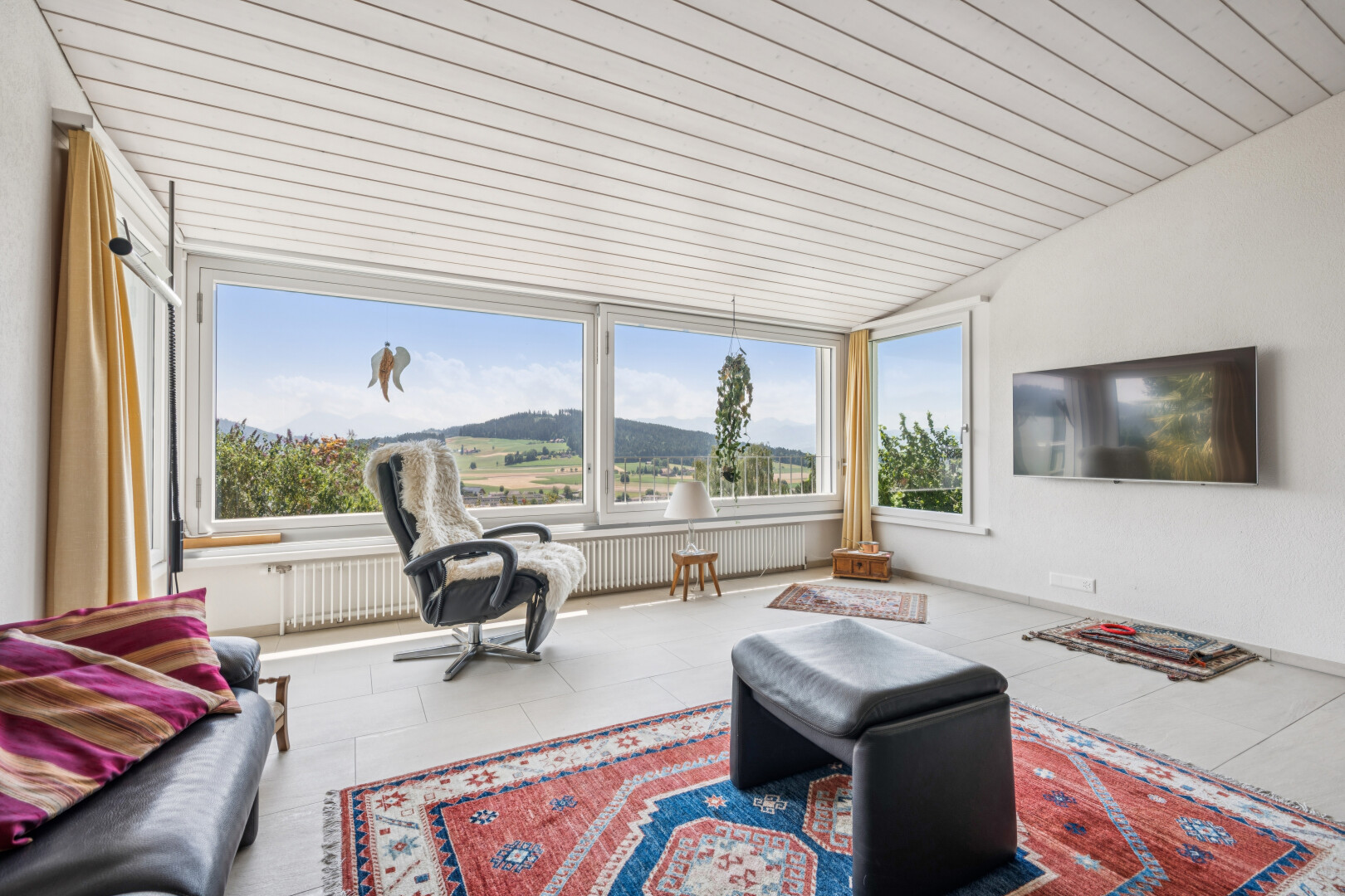 wohnzimmer mit fernseher, drywall, gipskartonwand, kühler, und vaulted ceiling