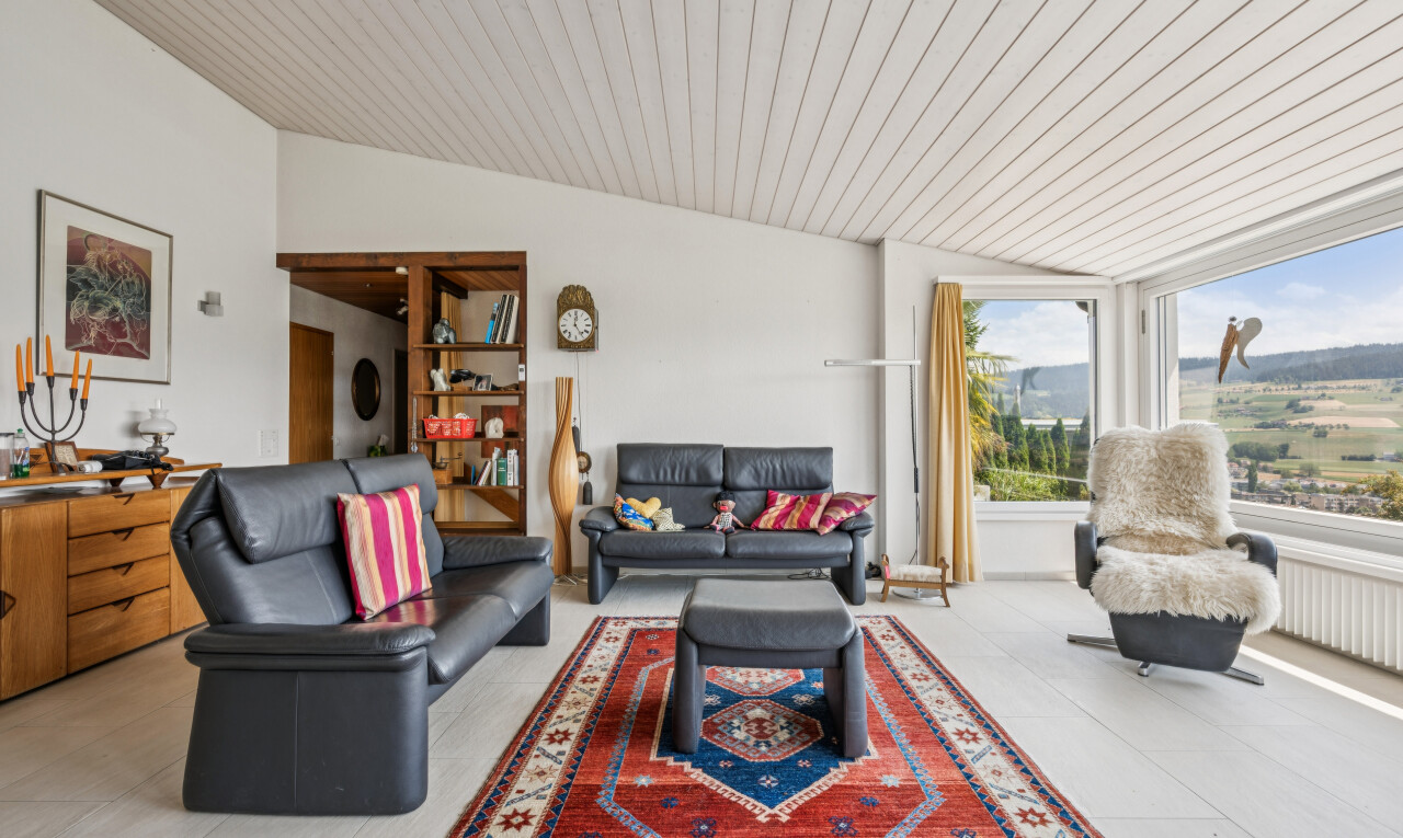 salon avec vaulted ceiling, plafond voûté, étagères intégrées, inside property, et drywall