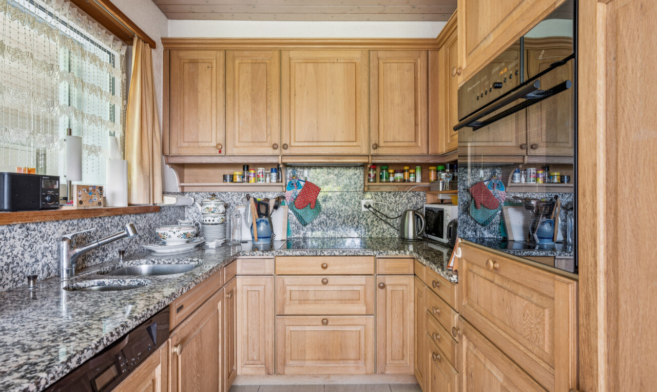 cuisine avec four, stone countertops, plans de travail en pierre, raised cabinets, et armoires élevées