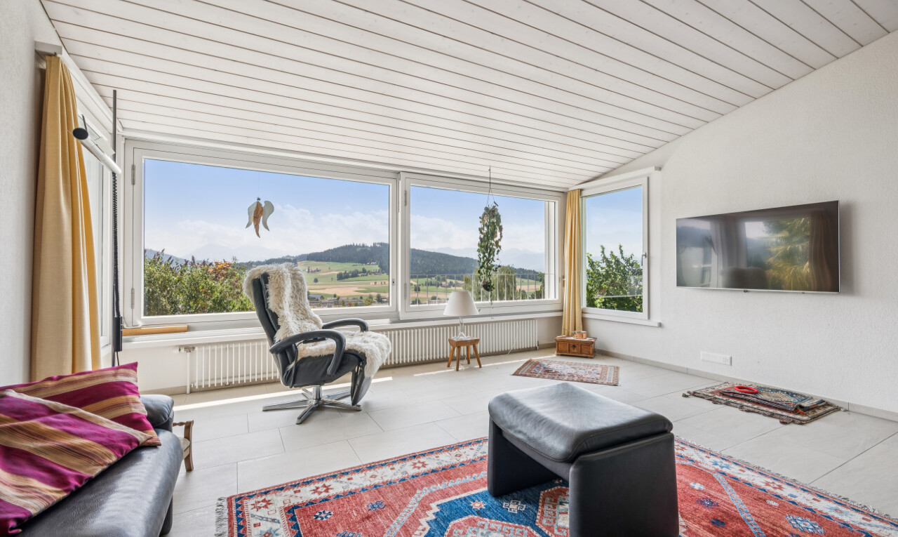 salon avec télévision, drywall, cloison sèche, radiateur, et vaulted ceiling