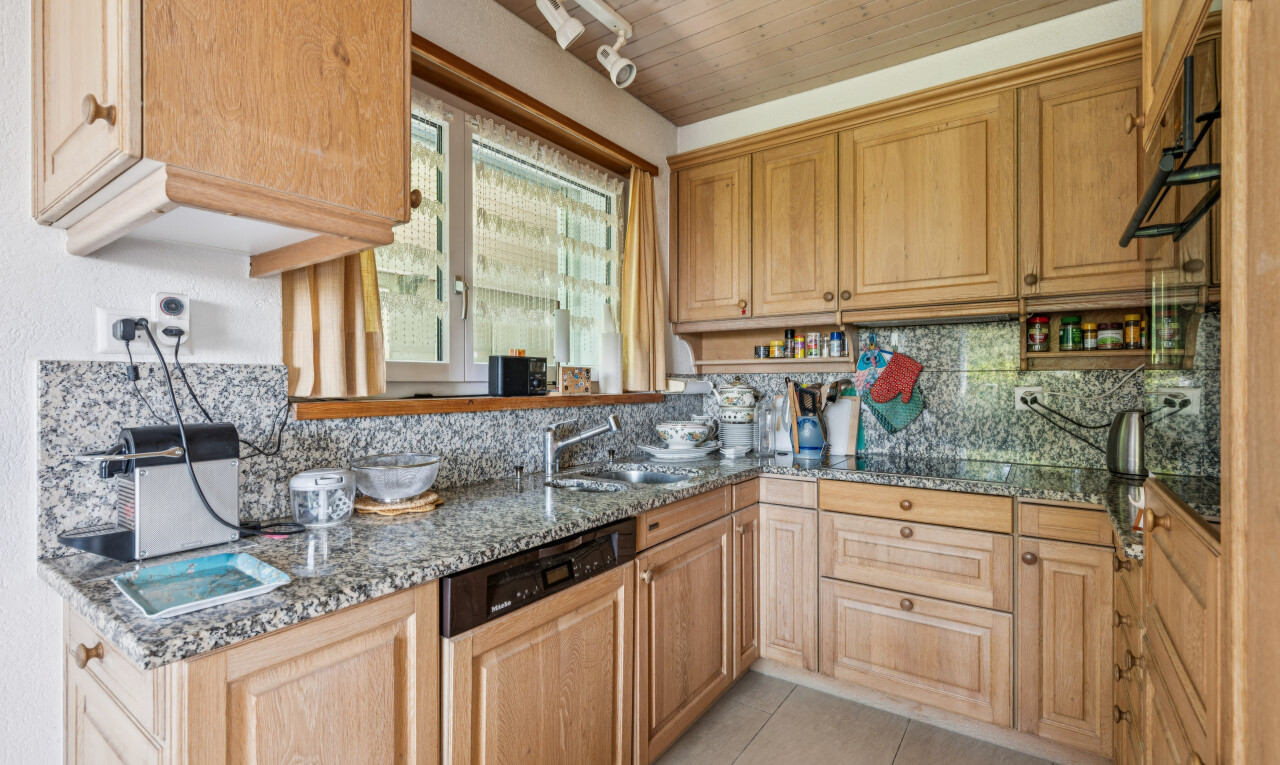 cuisine avec éclairage sur rail, stone countertops, plans de travail en pierre, lave-vaisselle, et light floor