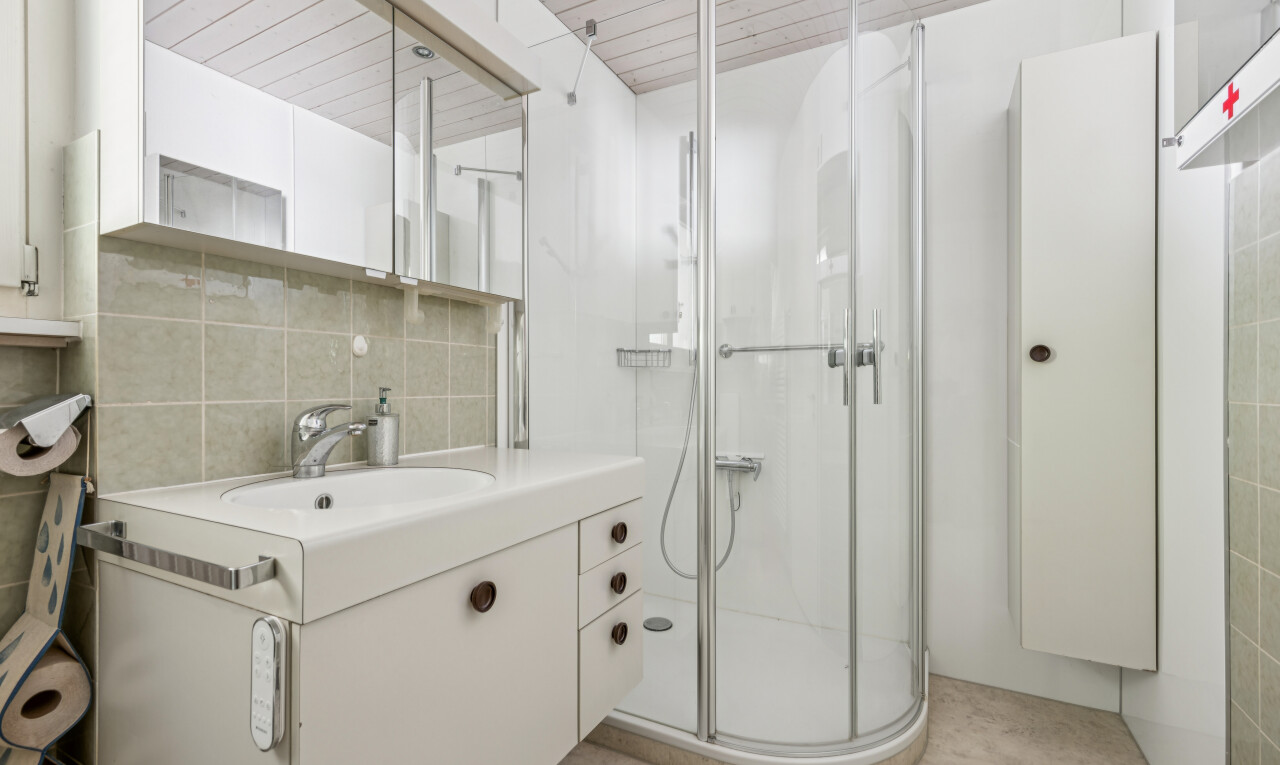 salle de bains avec lavabo (ou coiffeuse selon le contexte), miroir, douche, wood ceiling, et plafond en bois