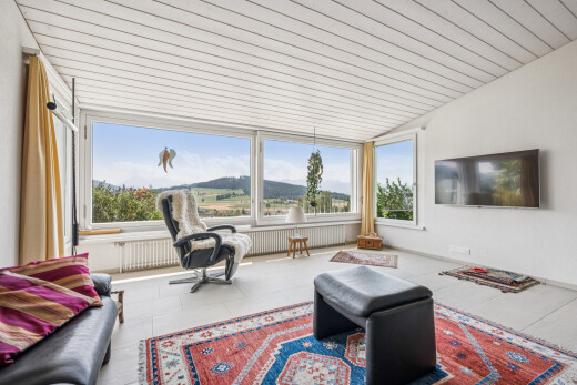 wohnzimmer mit fernseher, drywall, gipskartonwand, kühler, und vaulted ceiling