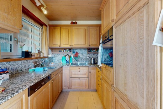 kitchen with light stone countertops, paneled dishwasher, wood ceiling, black oven, and light tile patterned flooring
