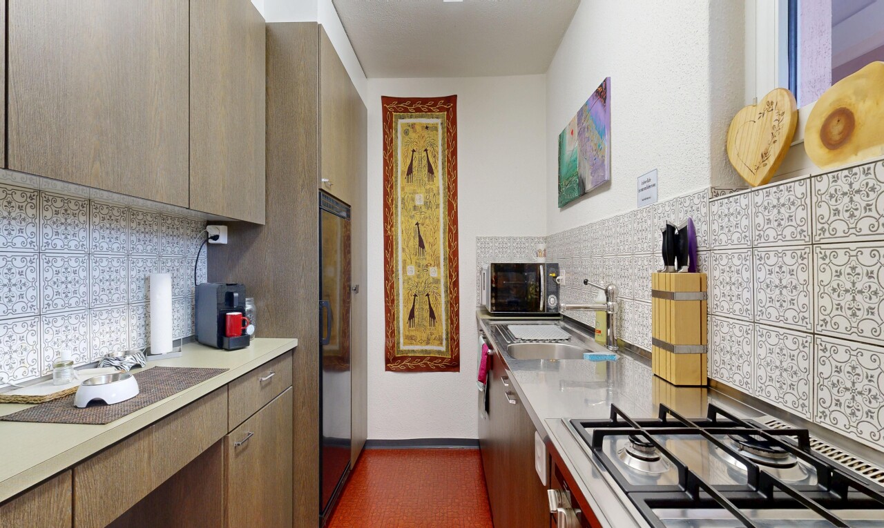 cuisine avec plans de travail, light countertops, plaque de cuisson, inside property, et évier