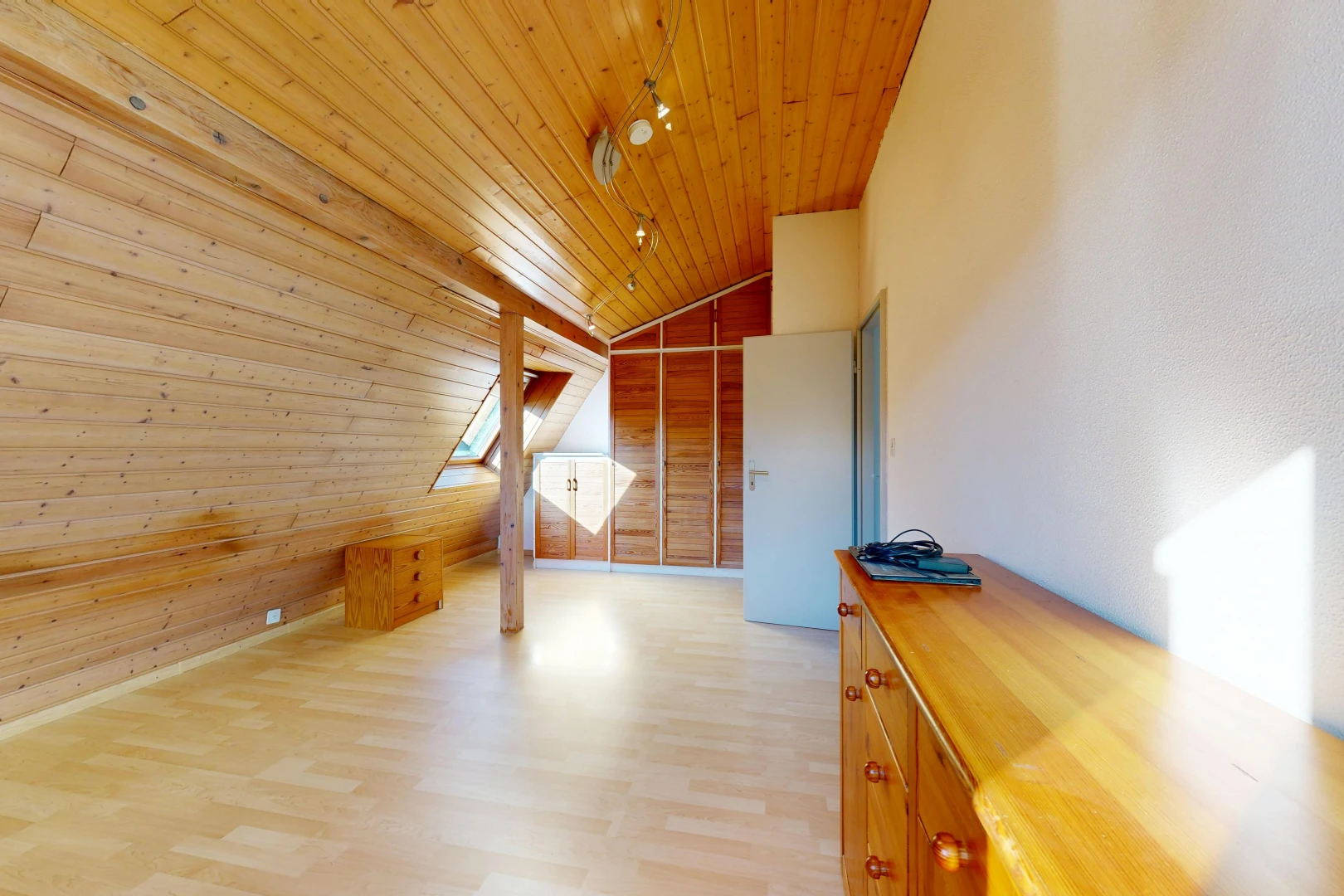 pièce vide avec plafond voûté, vaulted ceiling, plafond en bois, wood ceiling, et mur en bois