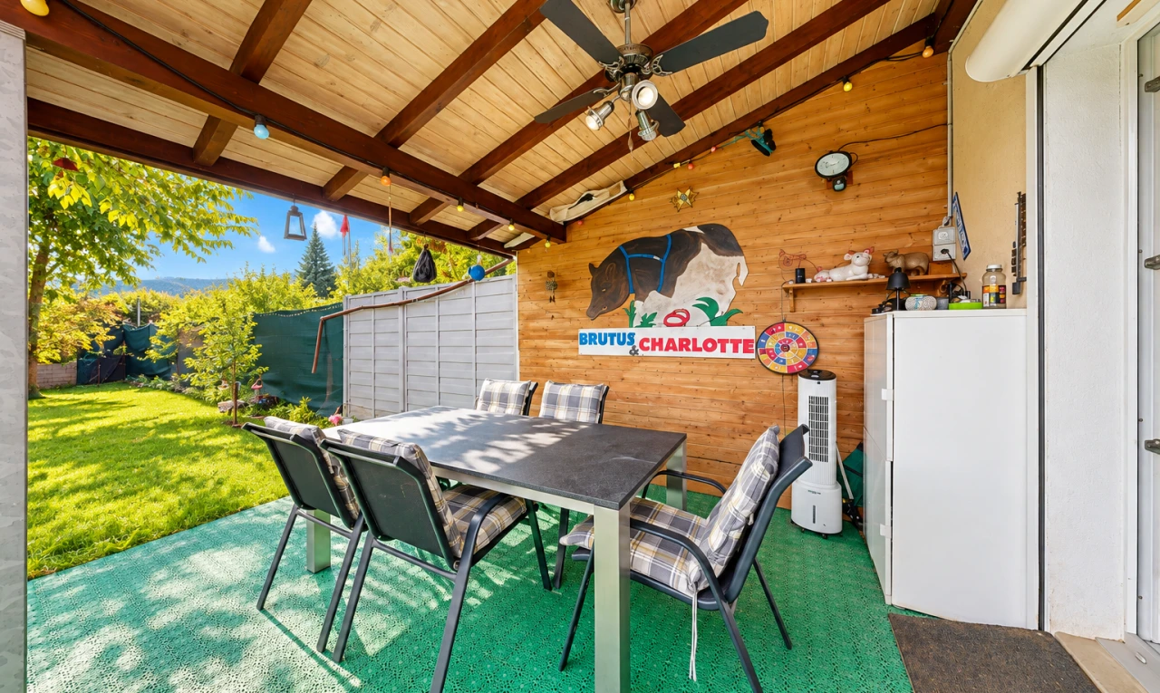 terrasse avec terrasse, ventilateur de plafond, coin repas extérieur, et pelouse