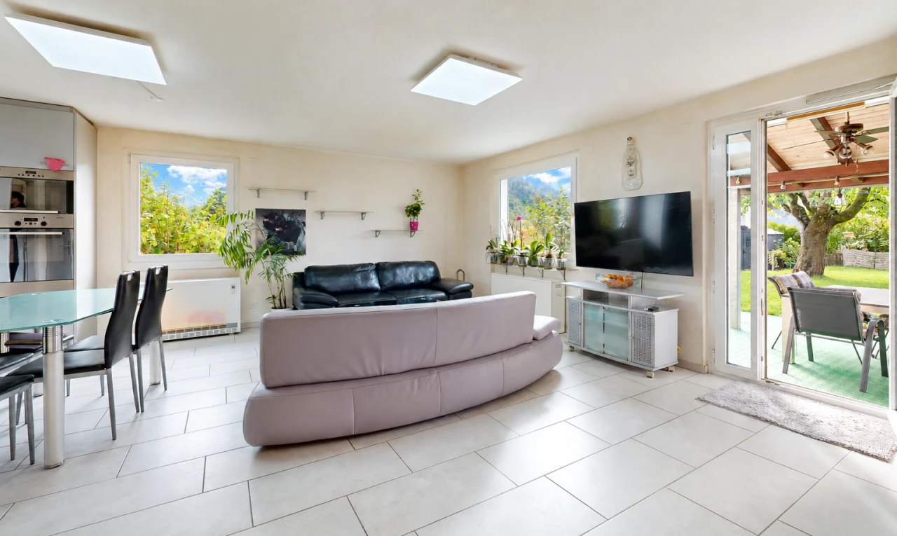 salon / salle à manger avec télévision, accès à l'extérieur, cloison sèche, drywall, et light floor