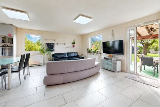 salon / salle à manger avec télévision, accès à l'extérieur, cloison sèche, drywall, et light floor