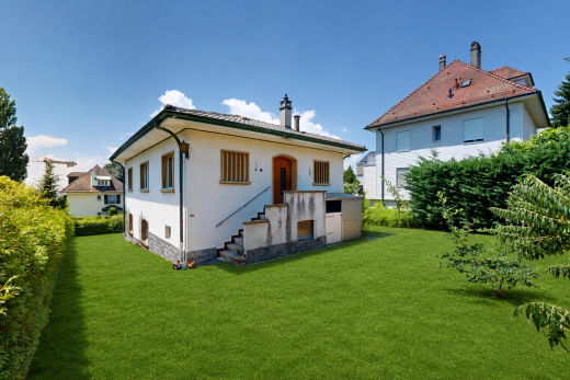 außenansicht mit day time, stuckverkleidung, property visible, schornstein, und rasen