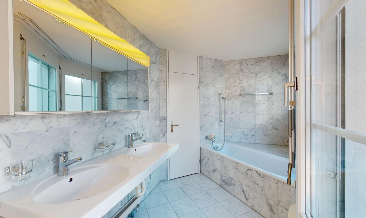 bad mit fliesenboden, spiegel, kombiniertes bad / dusche, doppelwaschbecken, und natürliches licht