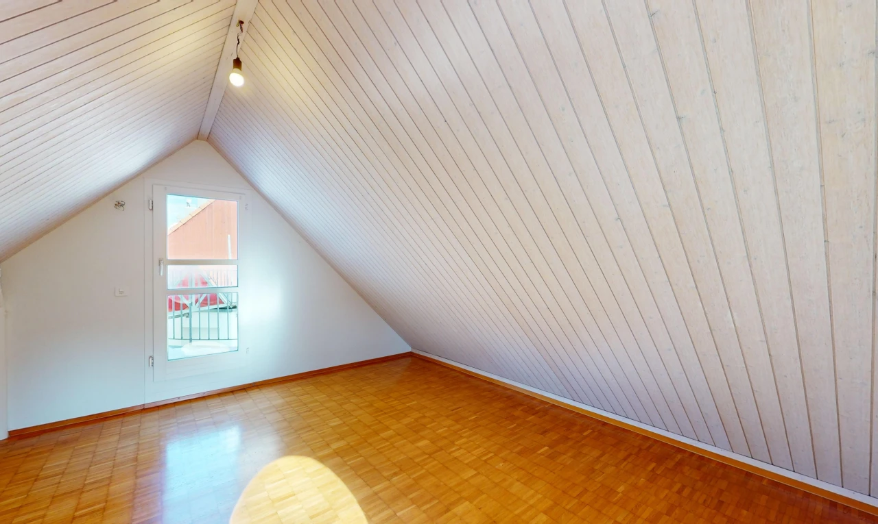 leerer raum mit dachschräge, parkettboden, niedrige decke, natürliches licht, und holzwand