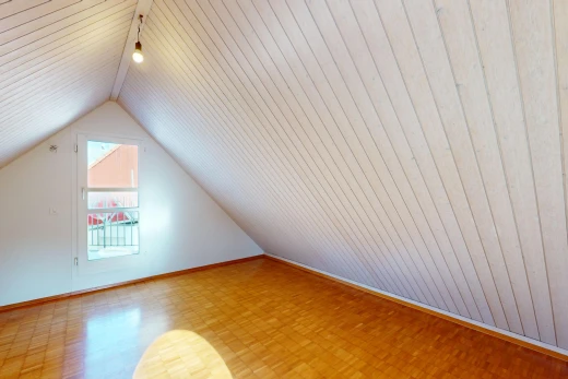 leerer raum mit dachschräge, parkettboden, niedrige decke, natürliches licht, und holzwand