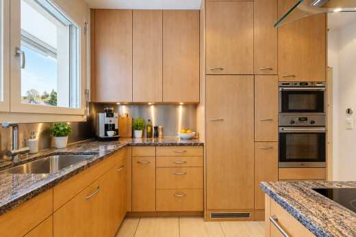 cuisine avec stone countertops, plans de travail en pierre, light floor, dark countertops, et évier