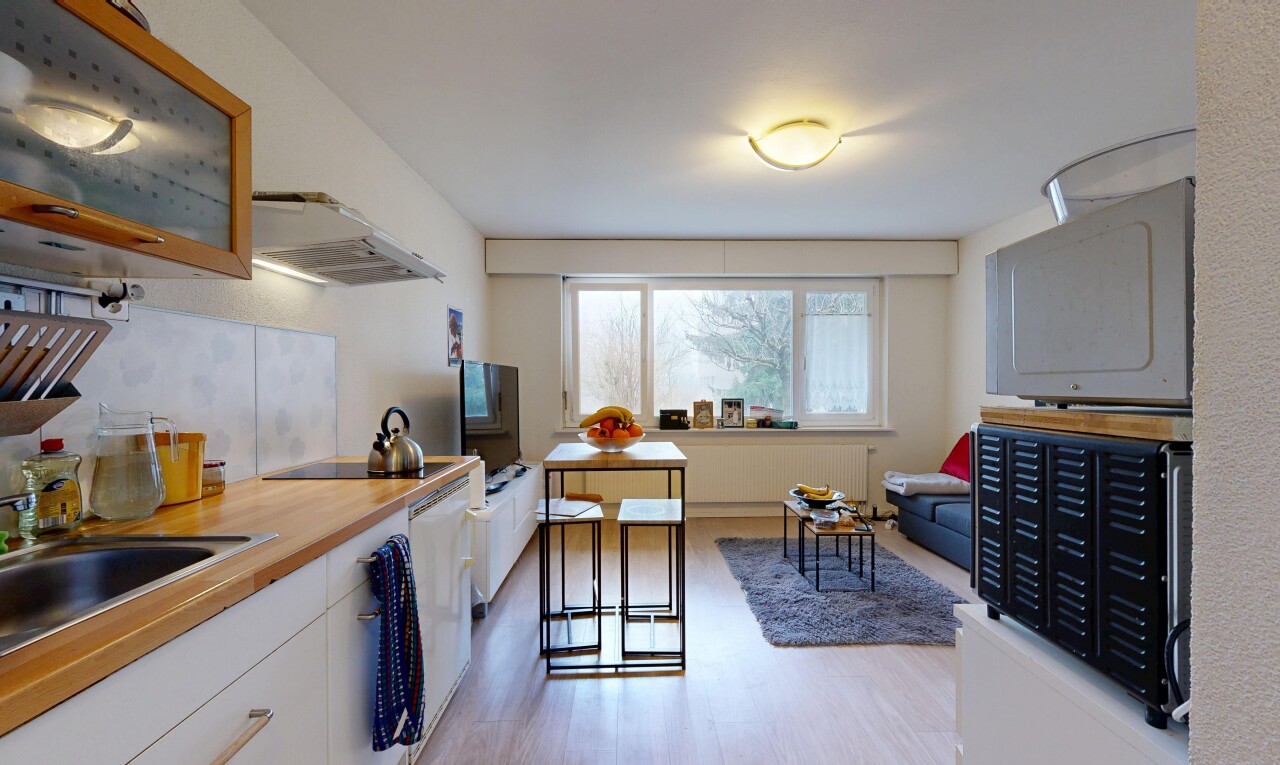 küche mit weiße schränke, dunstabzugshaube, arbeitsplatten, fernseher, und inside property