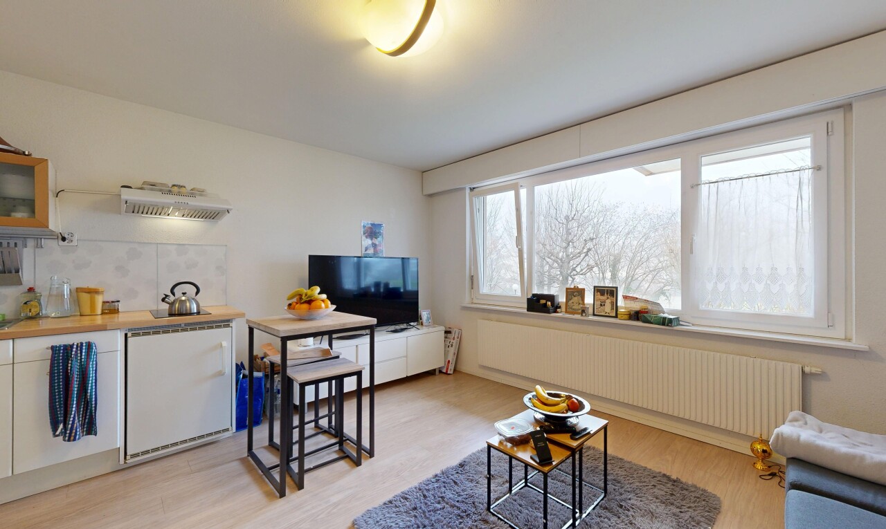 wohn- / esszimmer mit kühler, fernseher, holzfußboden, wood finish floor, und gipskartonwand