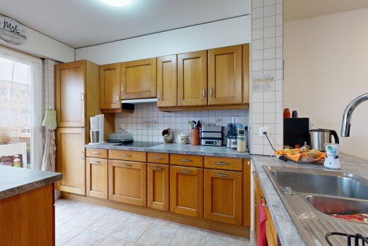 cuisine avec armoires marron moyen, évier, inside property, dosseret, et backsplash