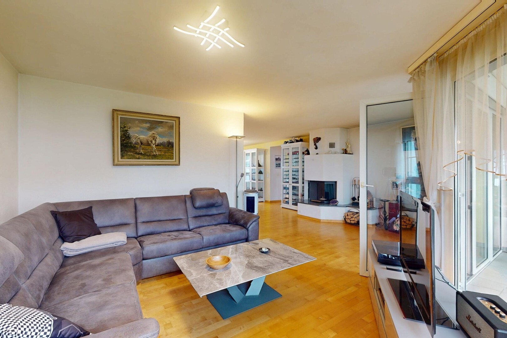 salon avec sol en finition bois, wood finish floor, cloison sèche, drywall, et télévision