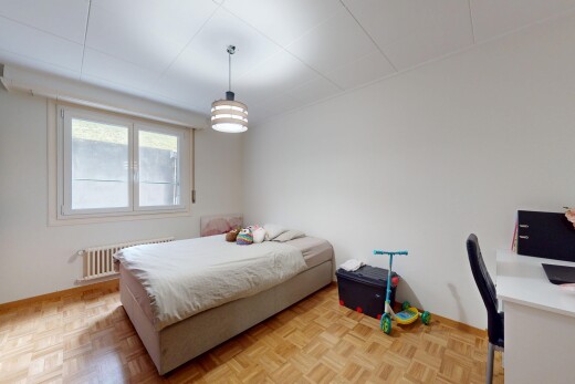 chambre avec télévision, lumière naturelle, espace bureau, radiateur, et cloison sèche