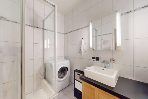 salle de bains avec miroir, salle de bain complète, douche, lave-linge et sèche-linge, et évier