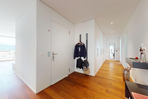 halle / korridor mit wood finish floor, holzfußboden, inside property, natural light, und natürliches licht