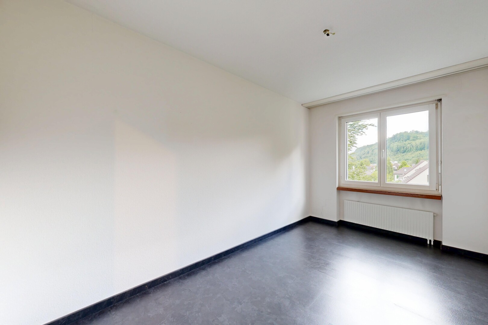 spare room featuring concrete flooring and radiator heating unit
